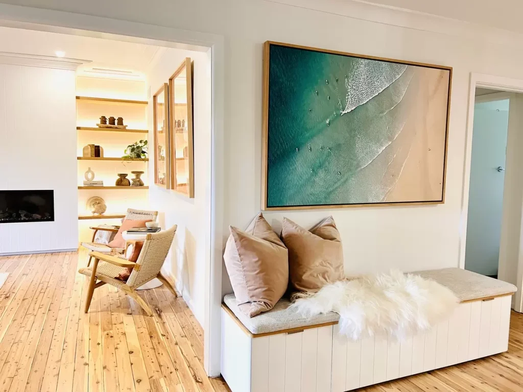 ariel photo of ocean and beach on the wall above a storage bench