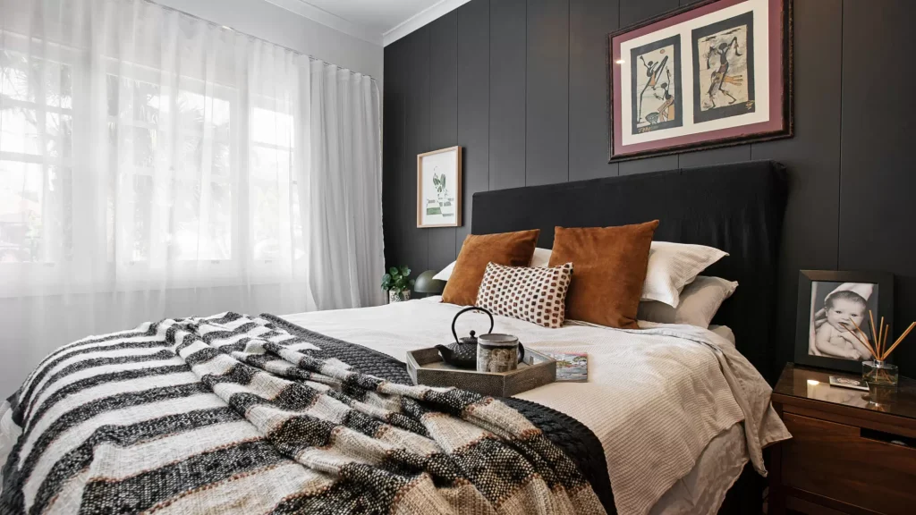 Black feature wall and warm textural styling in a master bedroom in Manly Vale, Northern Beaches, Sydney